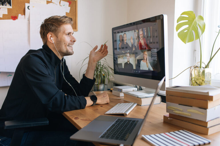 Young man having Zoom video call via a computer in the home offi